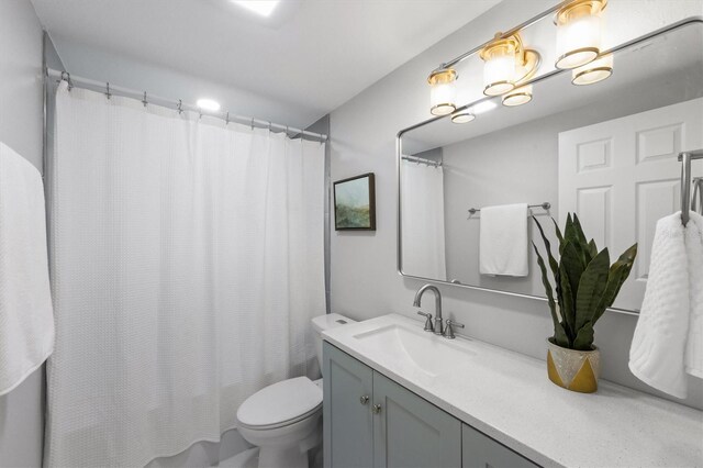 bathroom with vanity, a shower with shower curtain, and toilet