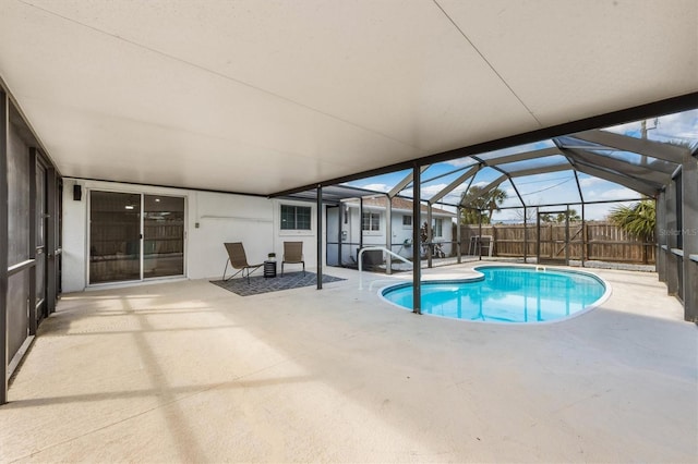 view of swimming pool with glass enclosure and a patio