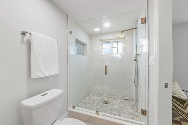 bathroom with toilet and a shower with shower door