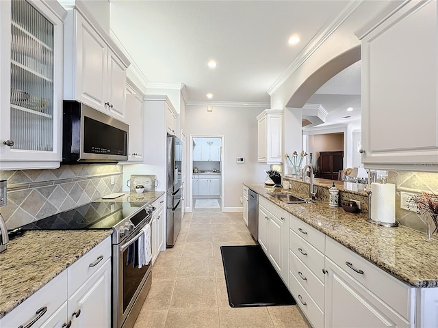 kitchen featuring decorative backsplash, white cabinetry, sink, and stainless steel appliances