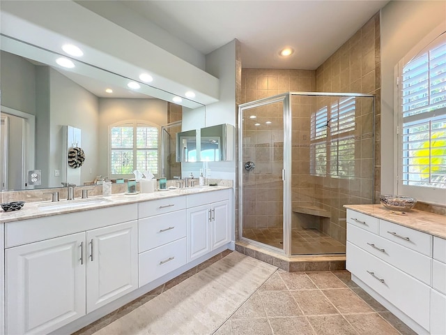 bathroom with tile patterned floors, a shower with door, and vanity