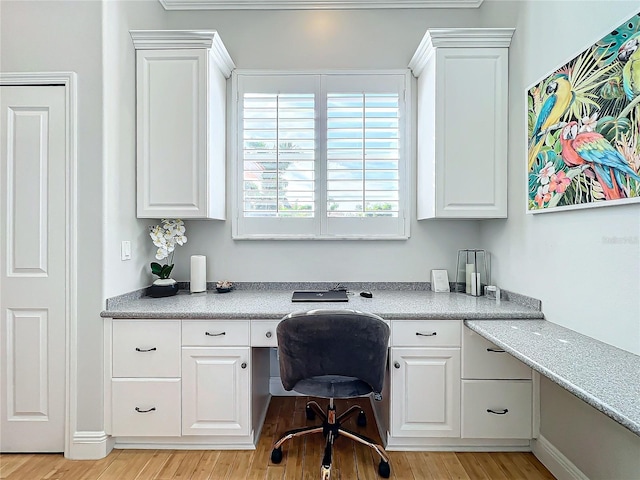 office area with light wood-type flooring and built in desk