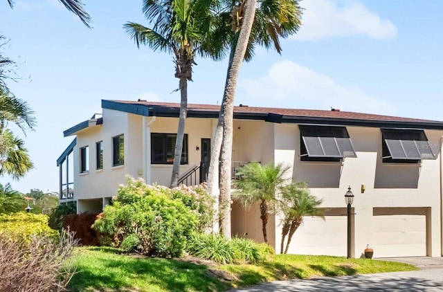 exterior space featuring solar panels, concrete driveway, an attached garage, and stucco siding