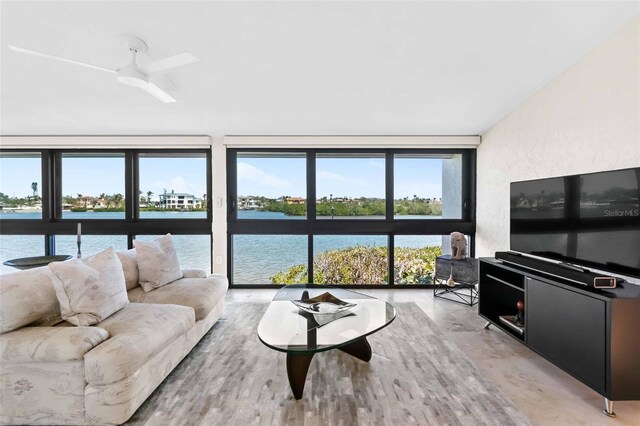 living room featuring a water view, a wall of windows, and a textured wall