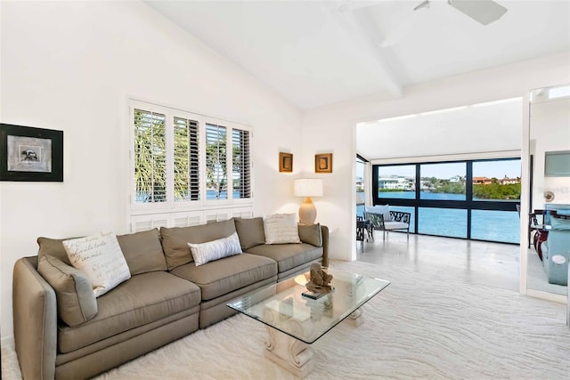 living room featuring lofted ceiling, a water view, and a ceiling fan