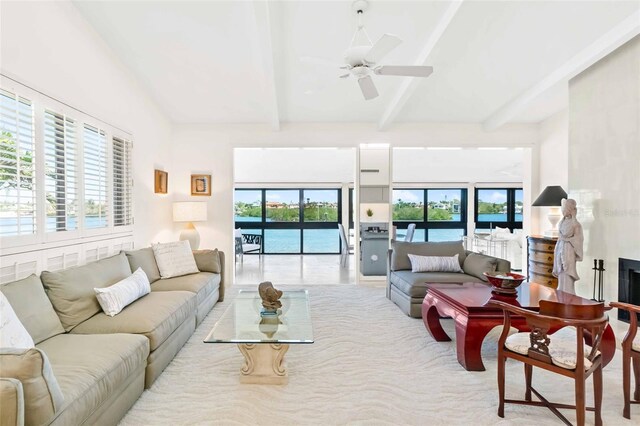 living room with beam ceiling, a healthy amount of sunlight, a fireplace, and ceiling fan