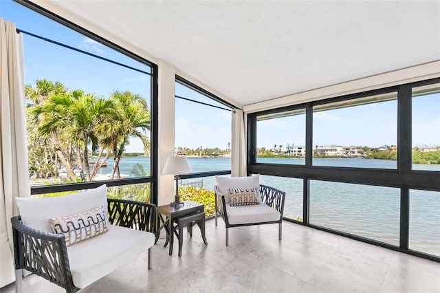 sunroom featuring a water view