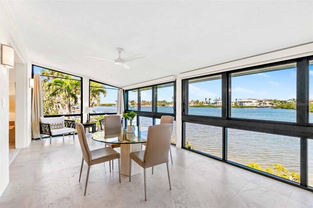 sunroom / solarium featuring a water view and ceiling fan