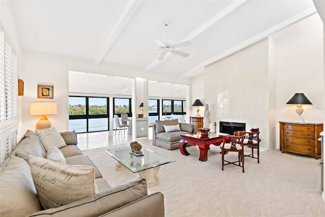 living room featuring light carpet, a ceiling fan, a high ceiling, a fireplace, and beam ceiling