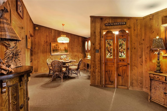 carpeted dining room with wooden walls