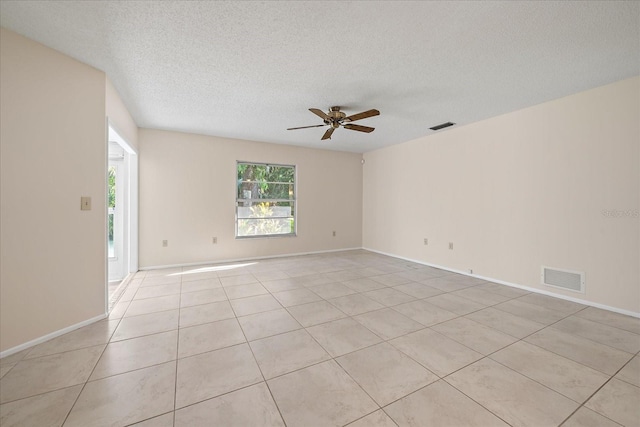 tiled spare room featuring a textured ceiling and ceiling fan