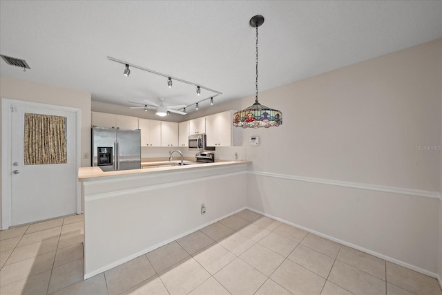 kitchen featuring kitchen peninsula, ceiling fan, stainless steel appliances, and decorative light fixtures