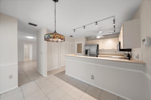 kitchen featuring ceiling fan, kitchen peninsula, pendant lighting, light tile patterned floors, and appliances with stainless steel finishes