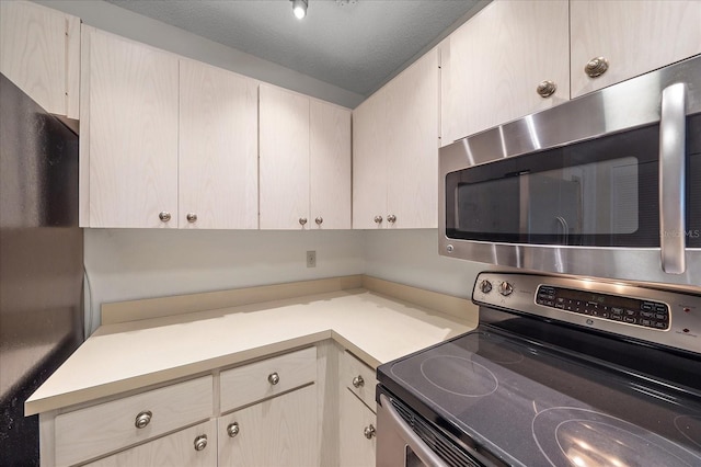 kitchen featuring a textured ceiling and stainless steel appliances