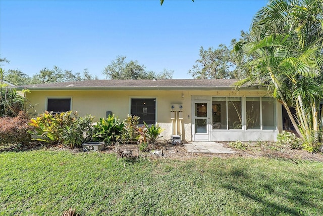 view of front of property featuring a sunroom and a front lawn