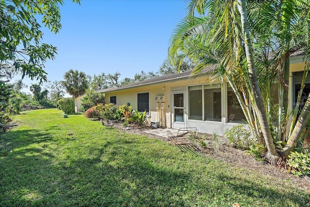 rear view of property with a lawn