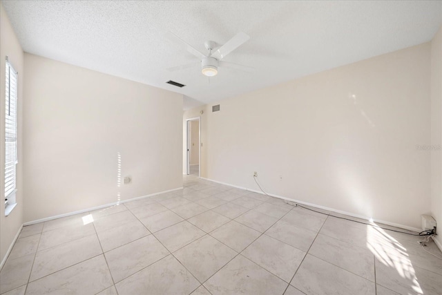 tiled spare room with ceiling fan and a textured ceiling