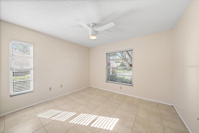 tiled spare room featuring ceiling fan and a textured ceiling