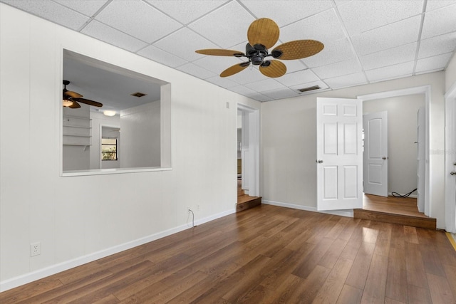 spare room featuring hardwood / wood-style floors, a drop ceiling, and ceiling fan