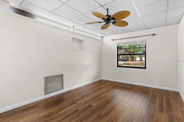 unfurnished room featuring a paneled ceiling, dark hardwood / wood-style floors, and ceiling fan