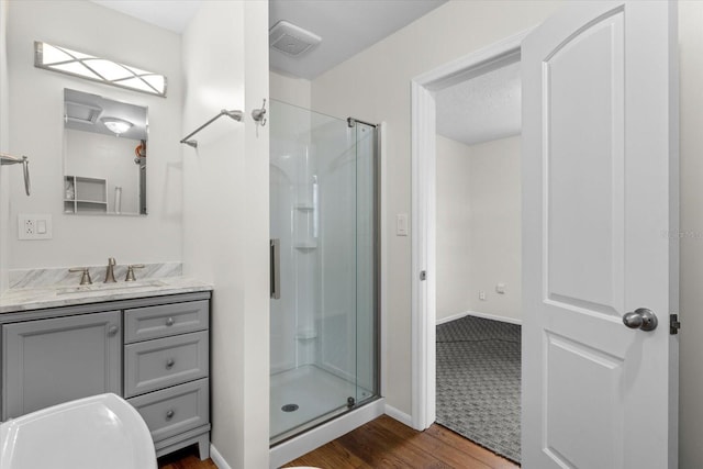 bathroom featuring hardwood / wood-style floors, vanity, and a shower with door