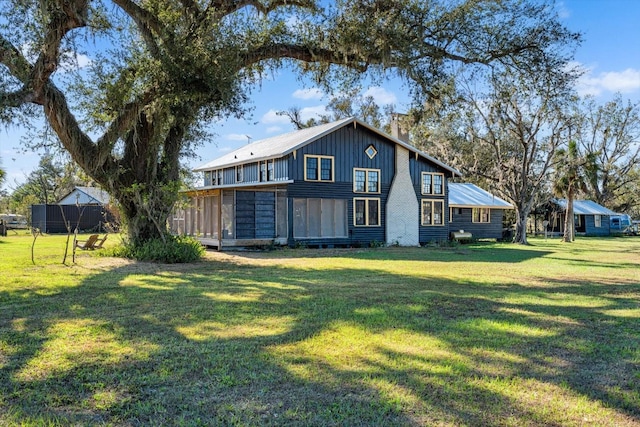 rear view of house featuring a lawn