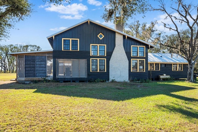 back of house featuring a sunroom and a lawn