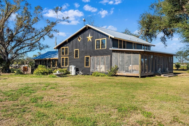 rear view of house with a lawn and a sunroom