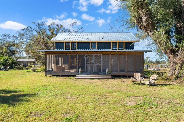 rear view of property featuring a yard and a sunroom