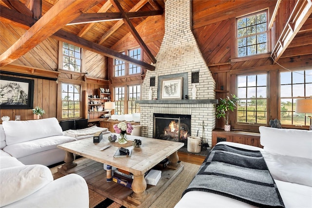 living room with wood-type flooring, high vaulted ceiling, a brick fireplace, and wood walls