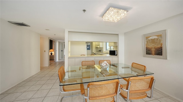 tiled dining space featuring an inviting chandelier