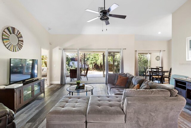 living room featuring a towering ceiling, dark hardwood / wood-style floors, and ceiling fan