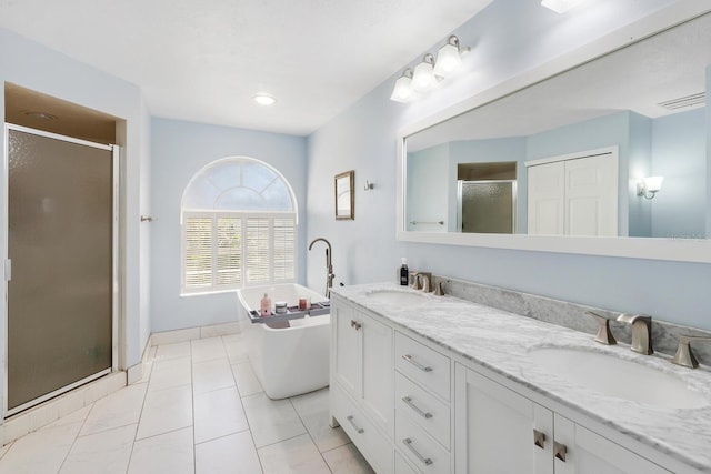 bathroom featuring plus walk in shower, vanity, and tile patterned floors