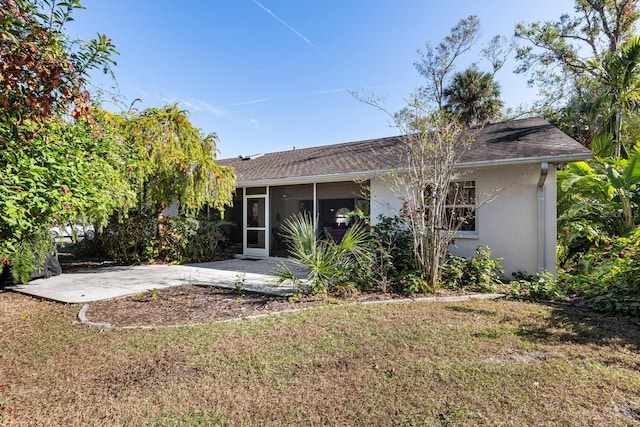 rear view of property with a patio, a lawn, and a sunroom