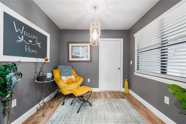 sitting room with a chandelier and hardwood / wood-style flooring