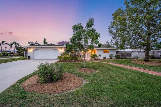 ranch-style home featuring a garage and a yard