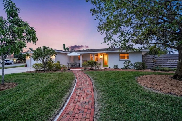 single story home featuring a yard and a garage