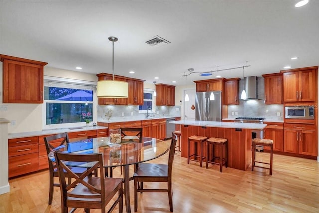 dining room featuring sink, light hardwood / wood-style floors, and track lighting