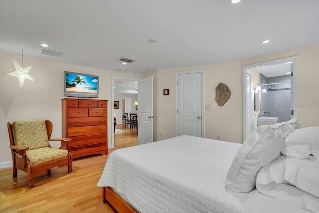 bedroom featuring ensuite bathroom and light hardwood / wood-style flooring