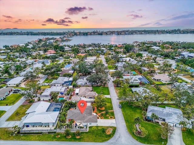 aerial view at dusk featuring a water view