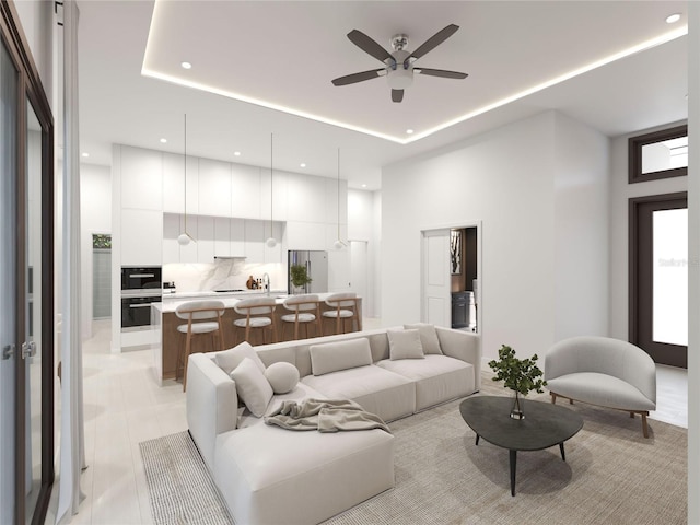 living room featuring a raised ceiling, ceiling fan, sink, and light tile patterned floors