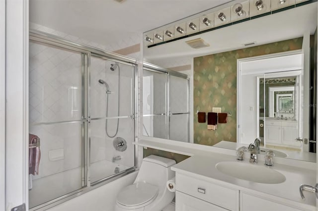 full bathroom featuring toilet, vanity, and combined bath / shower with glass door