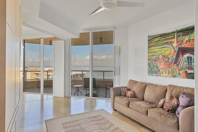 living room featuring a textured ceiling, expansive windows, and ceiling fan