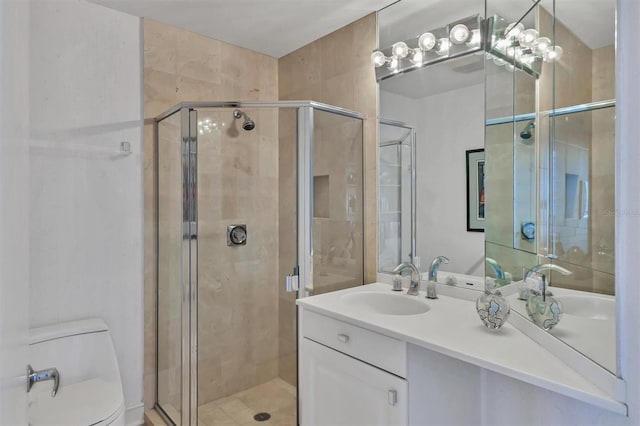 bathroom with vanity, toilet, and a shower with shower door