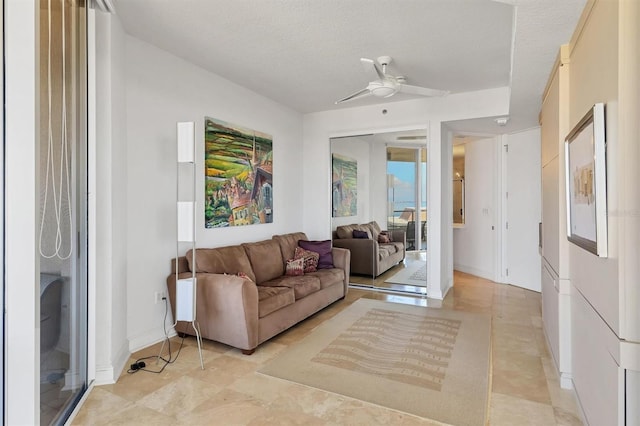 living room with ceiling fan and a textured ceiling