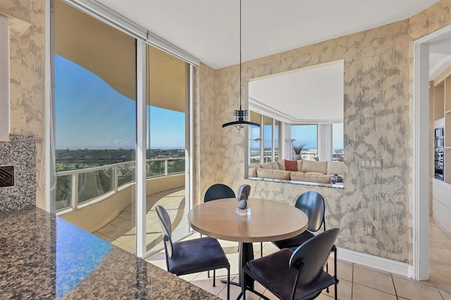 tiled dining space featuring floor to ceiling windows and a wealth of natural light