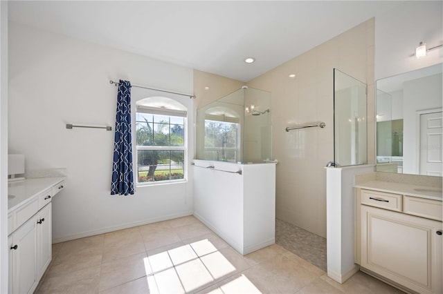 bathroom with tile patterned floors, vanity, and tiled shower