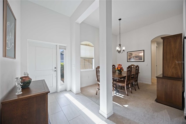 foyer with a chandelier and light carpet