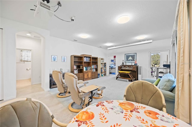 carpeted dining space with a textured ceiling