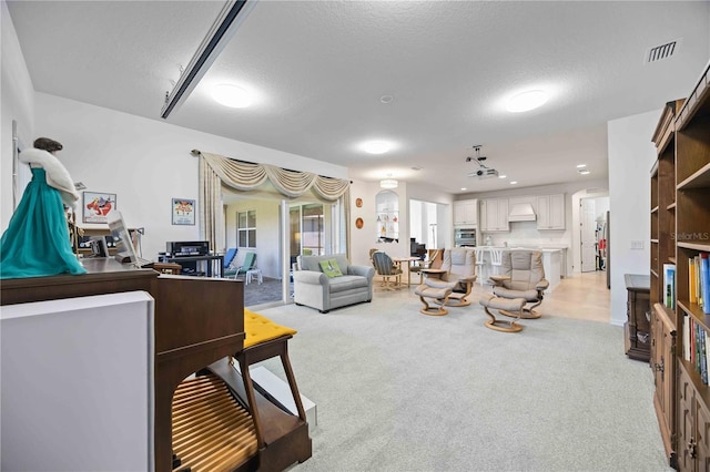 carpeted living room featuring a textured ceiling